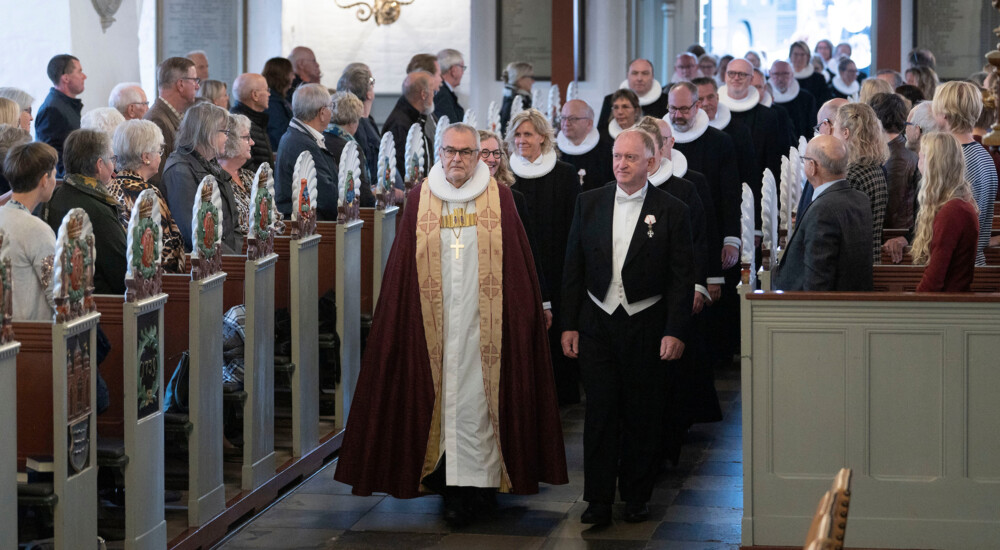 Biskop og stiftsamtmand fører an op ad kirkegulvet foran provster og præster