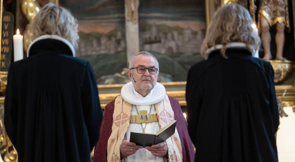 Henning Toft Bro står foran to præster