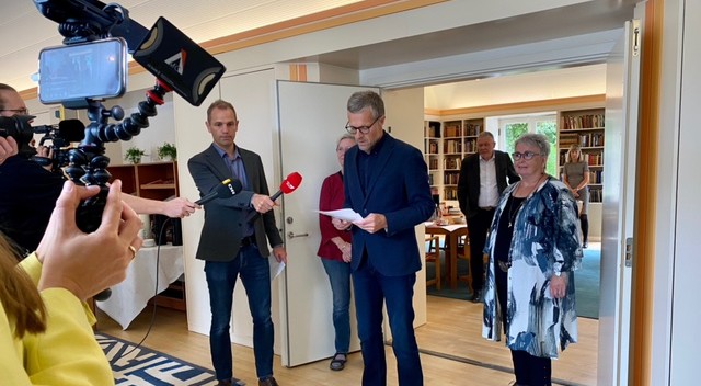 Folk med kamera og mikrofoner omkring Anders B. Hummelmose, som læser valgresultatet højt.