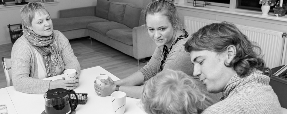 4 personer sidder omkring bord med kaffe