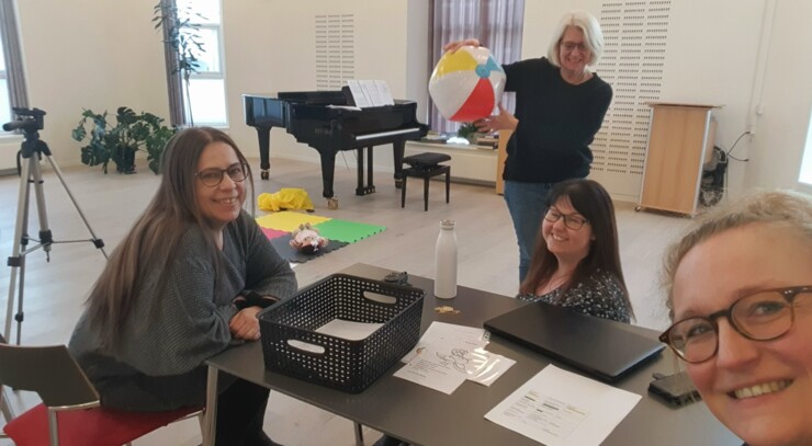 Kirke- og kulturmedarbejdere fra bykirkerne i Hjørring Rikke Bay, Birgitte Randsted og Katrine Bach Skovmand sidder ved bord og organist står med badebold Hanne Høy