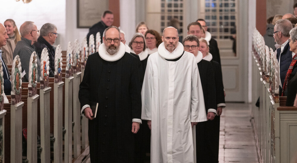 Cand. theol. Jack Nørdam Pedersen og domprovst Jakob Køhn Andersen går op ad kirkegulv