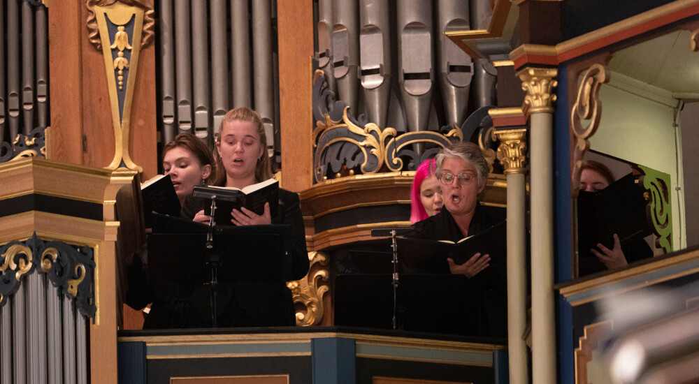 Kor står foran orgel og synger