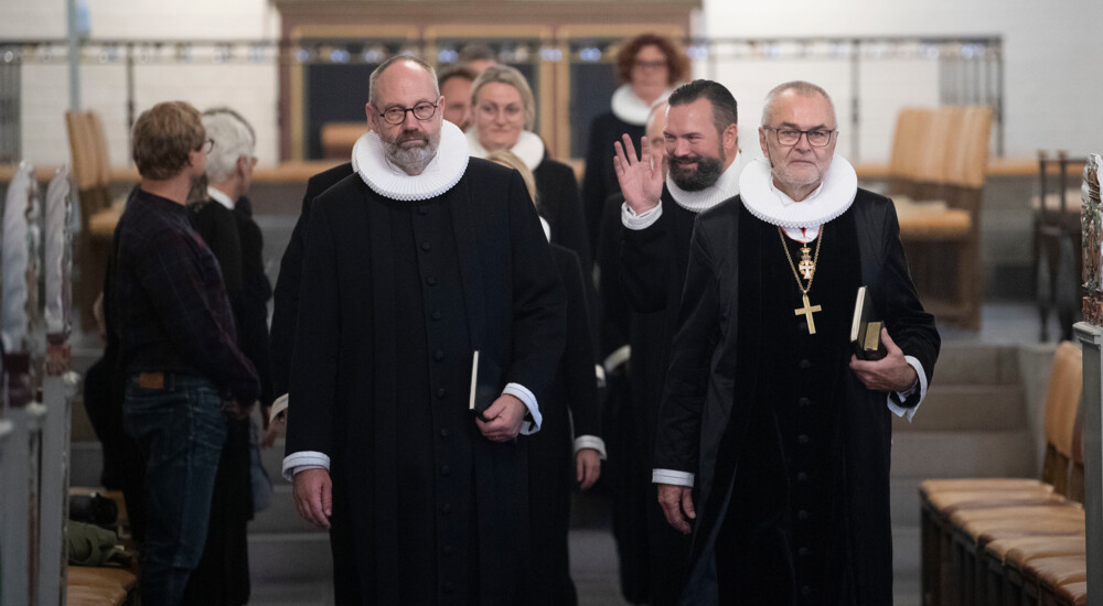 Præster på vej ud af kirke - Lars Östman vinker