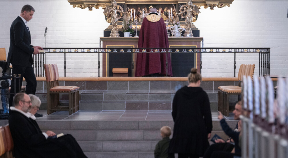 Biskop ses med ryggen til - står ved alter