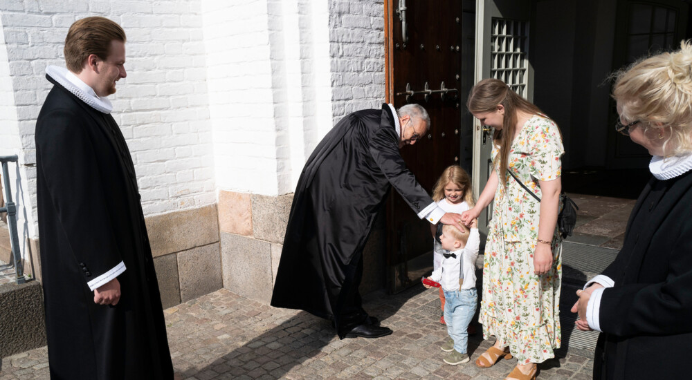 Biskop hilser på lille dreng udenfor kirke